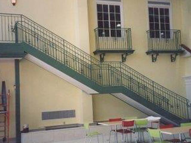 green metal staircase outside a building